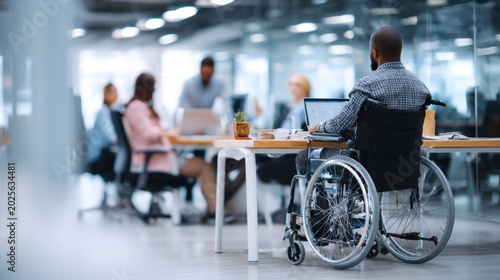 Inclusion in the Workplace: A dynamic team collaborates in a modern office, with a colleague in a wheelchair actively participating in the meeting, highlighting an inclusive work environment.