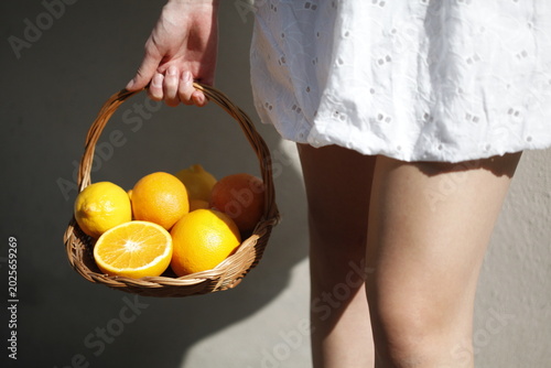 Woman Holding a Basket of Oranges