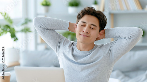 Asian office worker stretching shoulders after long computer work