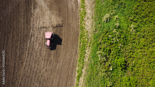 Canvas Print Aerial View of a Red Tractor Harrowing a Large Agricultural Field