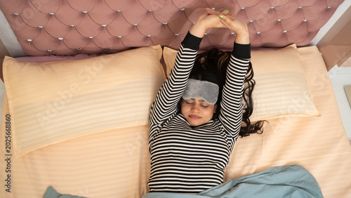 Indian Woman Waking Up in Morning and Stretching in Bed at Home