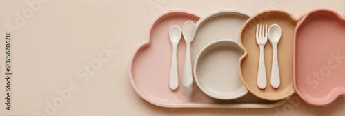 Obraz  z motywem Baby feeding accessories. First safe bear shaped plate, fork, spoon, bib. Silicone tableware, cutlery set on beige neutral background. Kids dishware concept. Serving child food. Solid color backdrop.