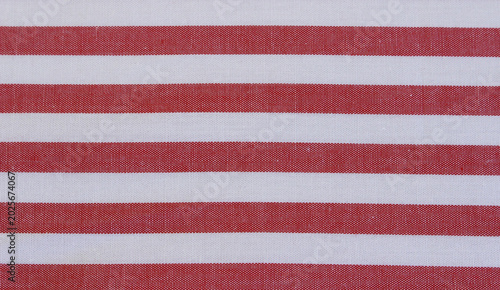 Texture of classic red striped cotton cloth background. Close up of red and white horizontal striped fabric. 