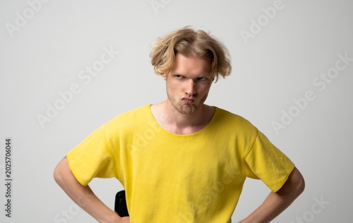 Canvas Print Young blond man experiencing anger and frustration, showing annoyance with a gru