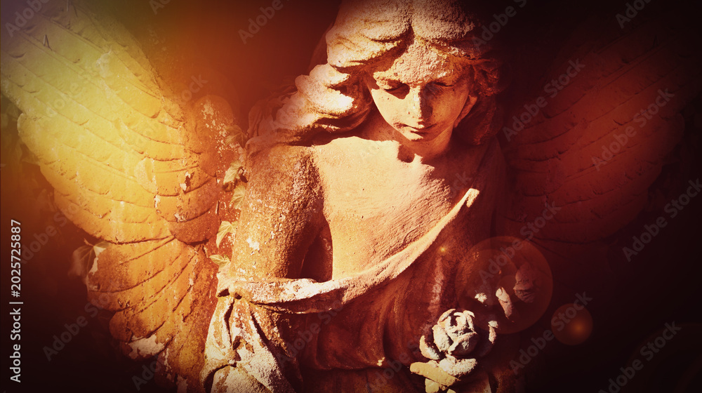 Obraz premium Gothic cemetery angel with illuminated wings and emotional atmosphere