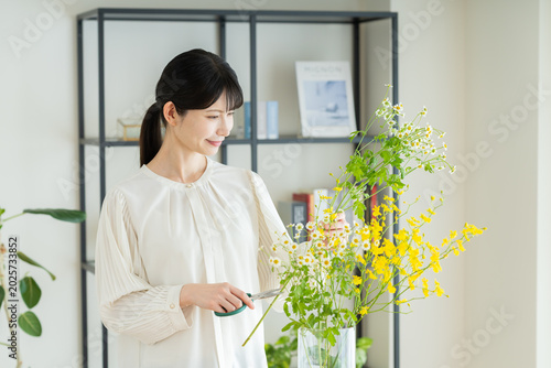 家で生け花をする若い女性