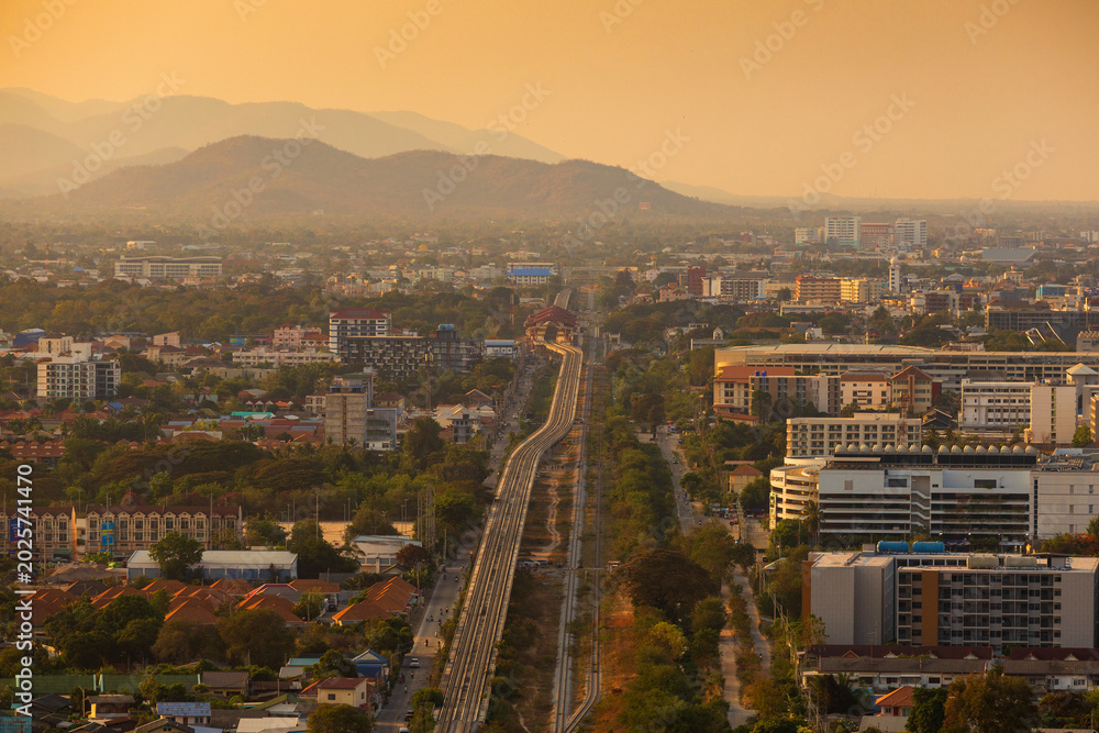 Obraz premium Aerial view of a sprawling city with mountains in the background during golden hour