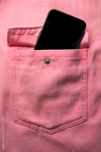 Fotografie Close-up of a jeans pocket with a pink sticker sticking out of the pocket