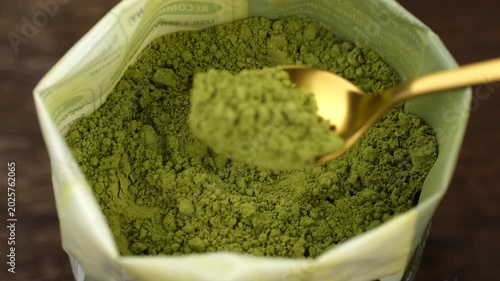 Matcha powder scooping with scoop from pack, closeup