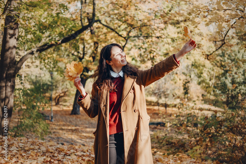 Bilde på lerret Woman stands among tall trees in autumn forest