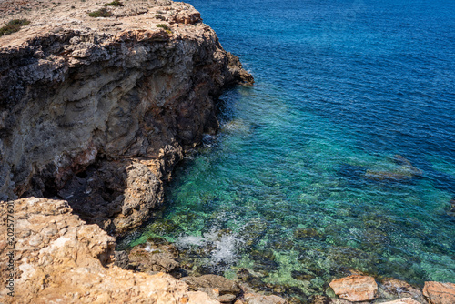 Obraz na płótnie Eroded limestone cliff meeting crystal clear emerald and turquoise Mediterranean