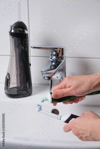 Daily toothbrush head cleaning procedure explained. Maintaining toothbrush hygiene during morning routine with effective rinsing