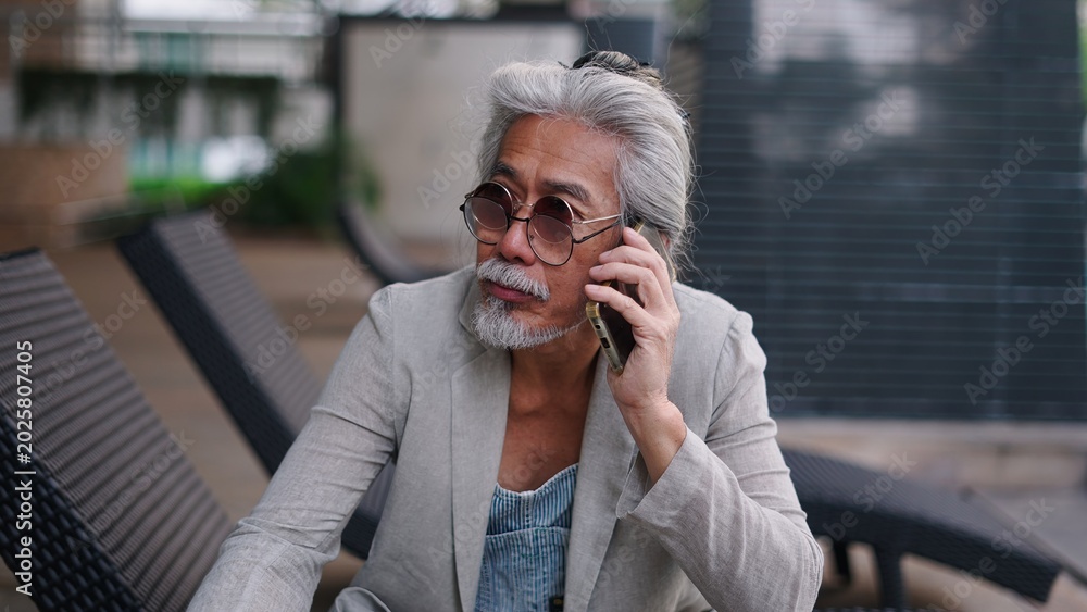Fototapeta premium Senior asian man talking on smartphone, communicating, connecting while relaxing