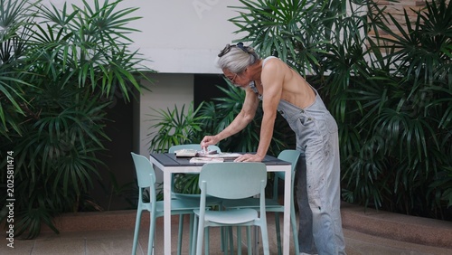 Slika na platnu Senior asian man painting art outdoors, enjoying creative hobby in garden