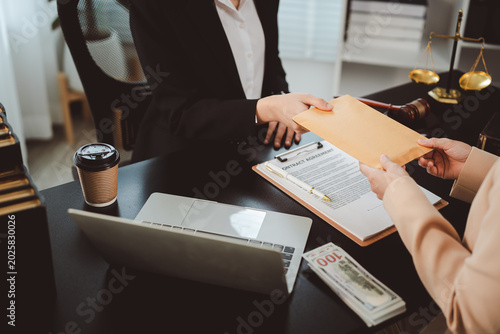 Obraz na plátně Person giving an envelope filled with cash to another person, symbolizing briber