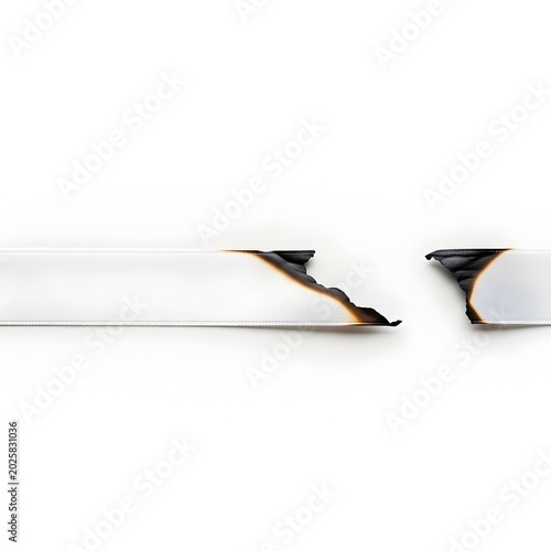 Burnt white paper strip with torn edges on a plain background