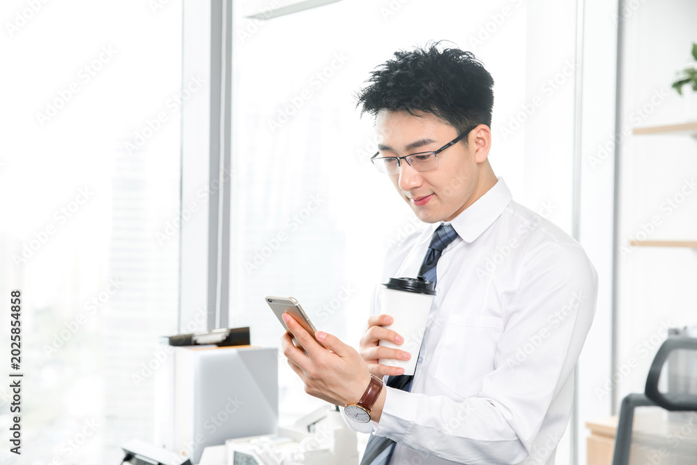 Fototapeta premium Businessman Using Smartphone and Coffee in Office