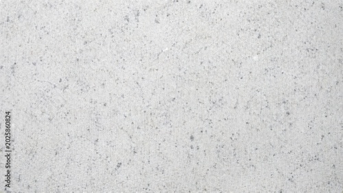 Light gray concrete wall texture with rough surface and small dark stone particles for background