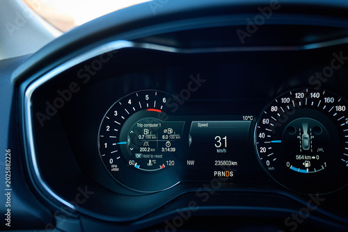Tableau sur toile Illuminated car dashboard with tachometer, digital speed display and trip computer screen