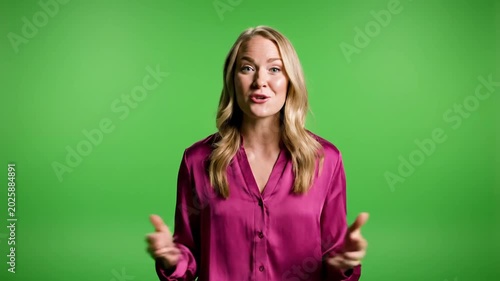 Woman Smiling and Gesturing in Front of Green Screen