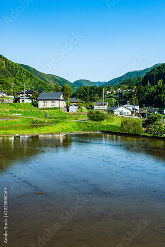 Foto 初夏の美ヶ原高原麓の山村風景と水田への映り込み