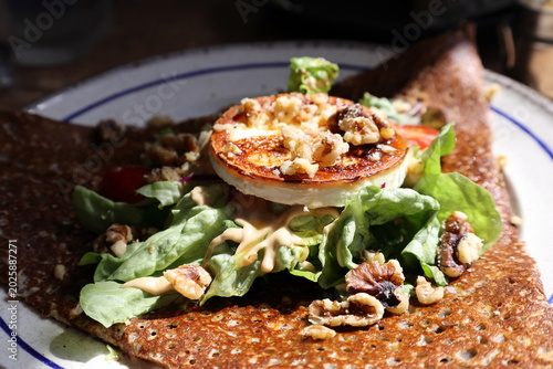Fotografie Warm french crepe with goat cheese, greens and nuts served at a cafe during lunchtime