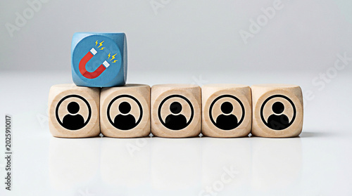 Wooden cubes with person icons and a magnet symbol representing effective customer lead generation strategies today