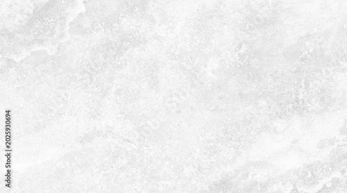A close-up shot of a light-colored, textured surface with subtle marbling and organic patterns, resembling natural stone or aged paper