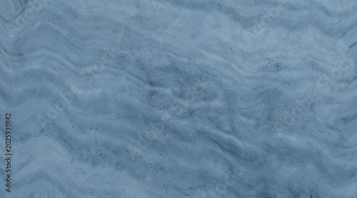 A close-up macro shot of a beautiful blue marble texture with wavy, organic lines and a smooth, polished finish