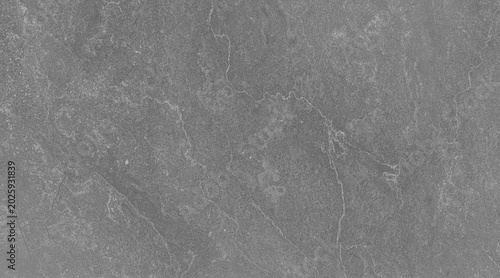 Photos Close-up view of a grey textured stone surface, possibly slate or granite, with subtle linear patterns and natural imperfections