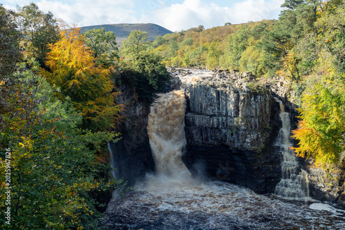 Photos Powerful High Force waterfall plunging through rocky gorge amid autumn trees and misty spray on the River Tees