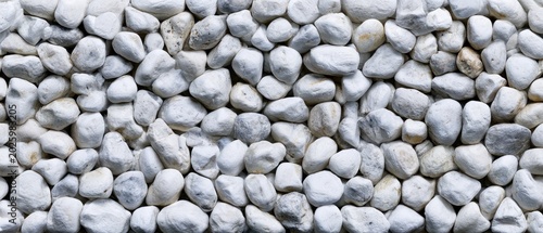 A close-up view of smooth, rounded white pebbles tightly packed together