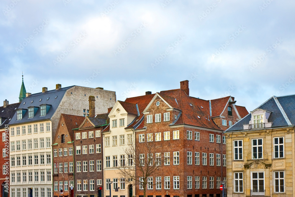Obraz premium COPENHAGEN - Scenic row of traditional European buildings in central Copenhagen, Denmark, featuring classic architecture, red rooftops, and charming facades