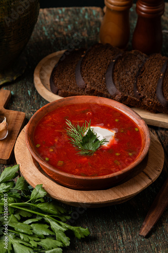 Traditional Ukrainian borscht soup with sour cream and spoon top view