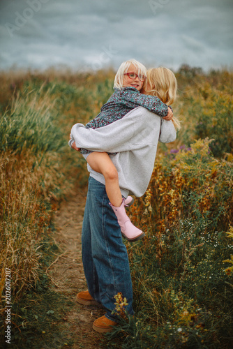 Happy sisters hugging outdoors before a storm – candid family lifestyle portrait