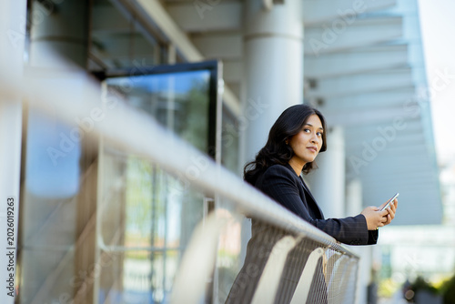 Woman standing by balcony h...