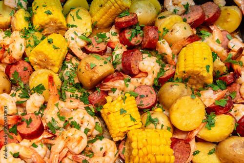 Home made shrimp boil with sausage, potatoes, corn and shrimp sprinkled with parsley