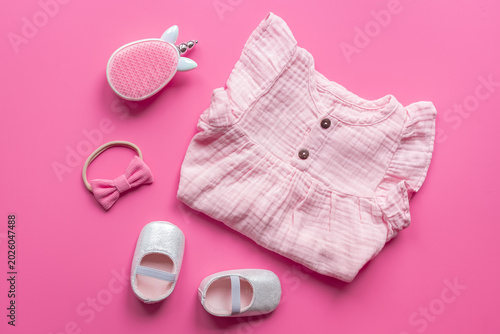 Photos Baby girl pink cotton muslin dress with shoes and unicorn-shaped accessories, top view