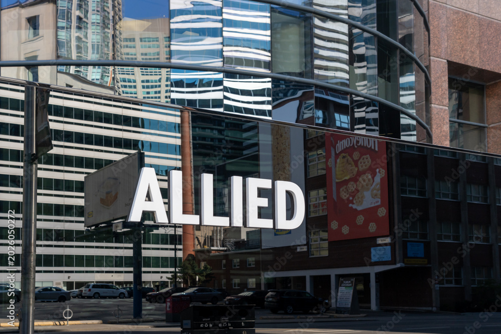 Fototapeta premium Toronto, Canada - May 18, 2026: A closeup signage for Allied at an office building in Toronto, Canada. Allied Properties REIT is a leading owner and developer of urban office space that enhances profi