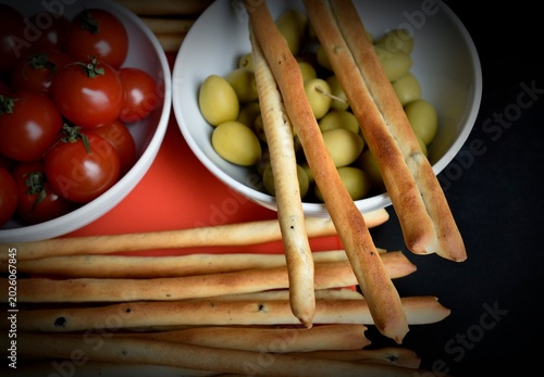 Bild auf Leinwand cherry tomatoes, green olives, and grissinis breadsticks