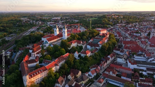 Freising, Bavaria, Germany, seen from a drone, reveals the cathedral hill with Dom St. Maria und St. Korbinian, St. George Church, and historic rooftops glowing in the summer sunset.