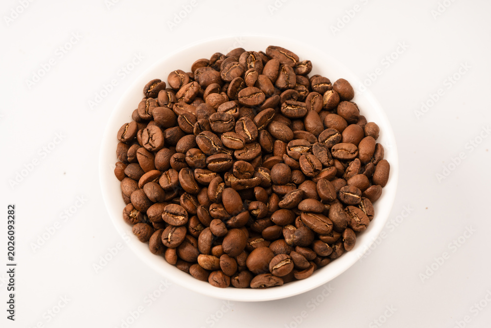 Fototapeta premium Coffee beans on a white background. Top view. Coffee beans texture.