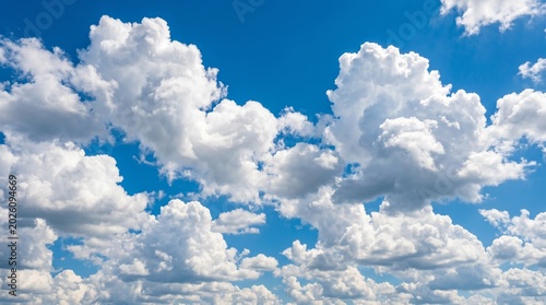 Billede på lærred Vast azure sky covered with dramatic, prominent white cumulus clouds on a bright