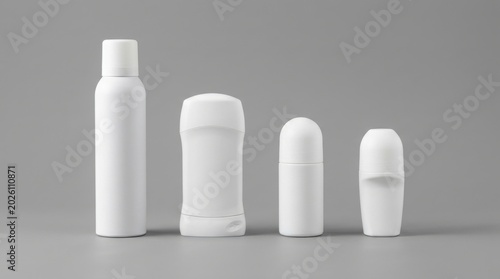 Four white antiperspirant and deodorant containers on gray background with roll on, deodorant
