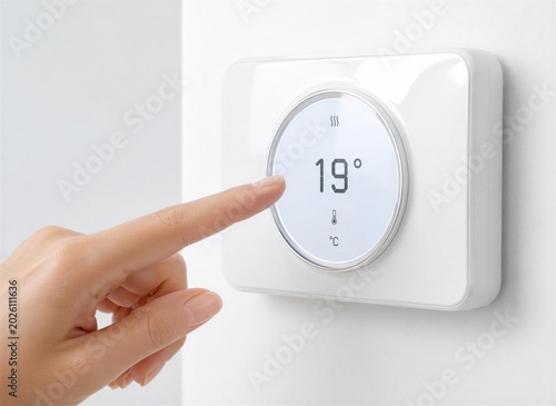 close up of a hand holding a remote control for ambient clima