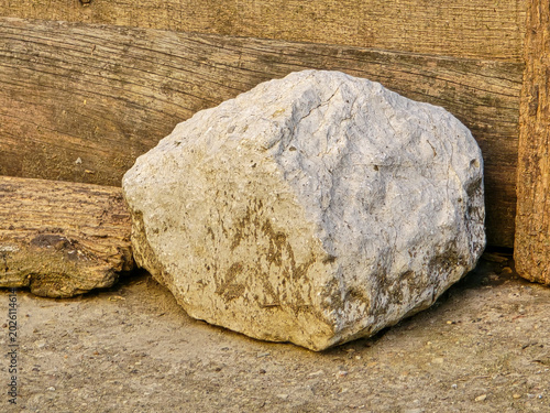 Photos Large white limestone rock in front of old weathered wooden logs