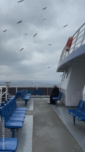 Handheld video of a lonely passenger sitting on the deck of a sailing ferry