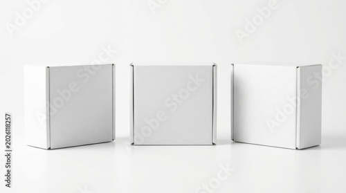 Three small blank white cardboard boxes in a row with cardboard packaging isolated shipping