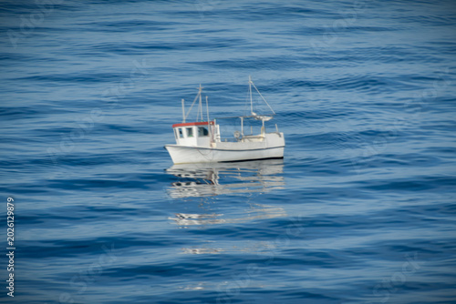 Ein kleines weißes Fischerboot auf dem weiten Meer