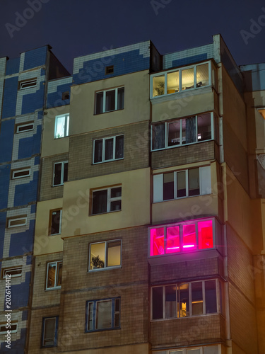 Night view of a apartment building with glowing windows in the city